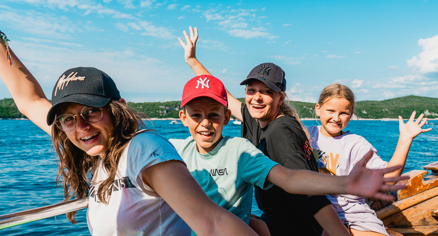 Kinderen poseren blij in de zon op een boot