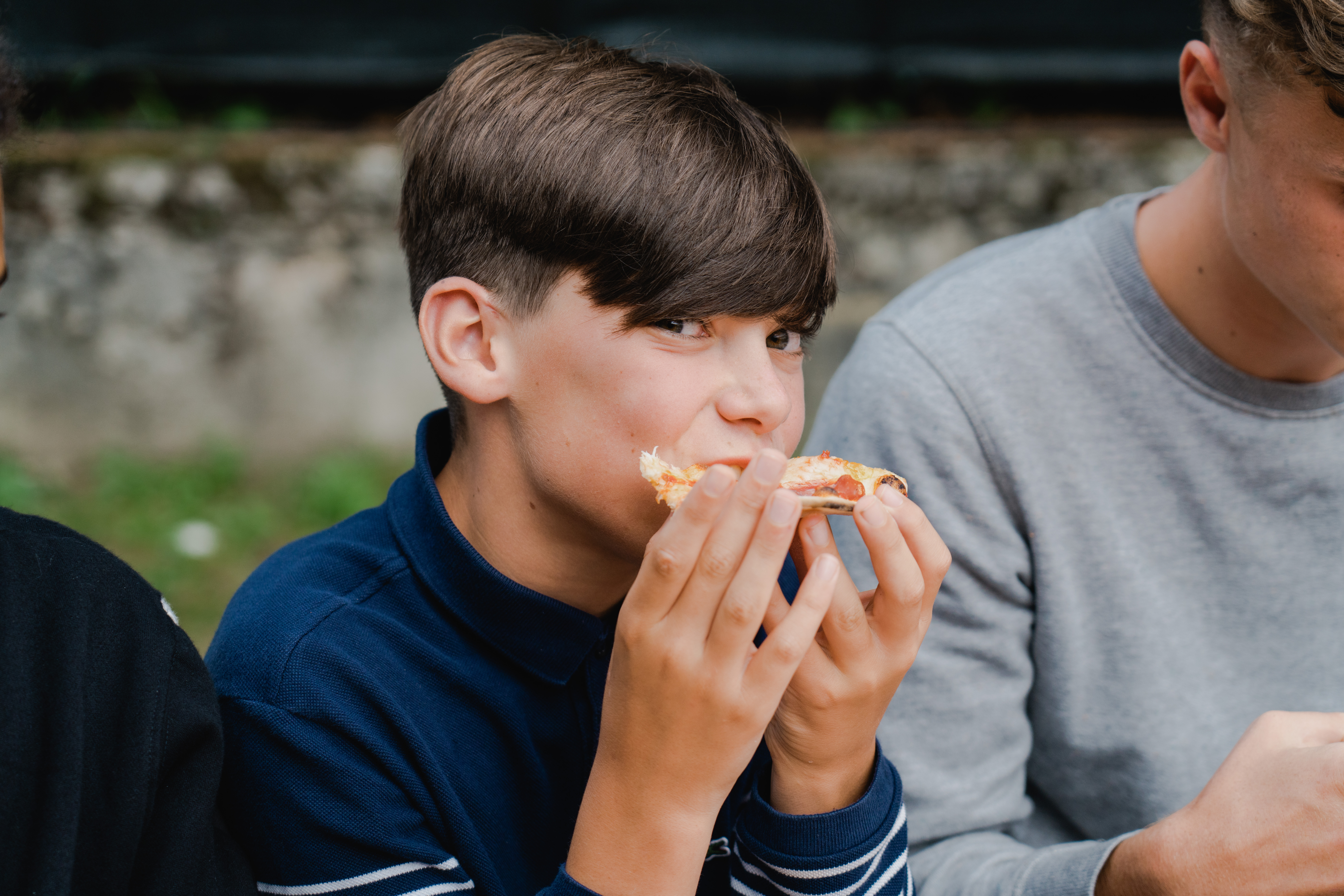 Een jongen smult van zijn pizza 