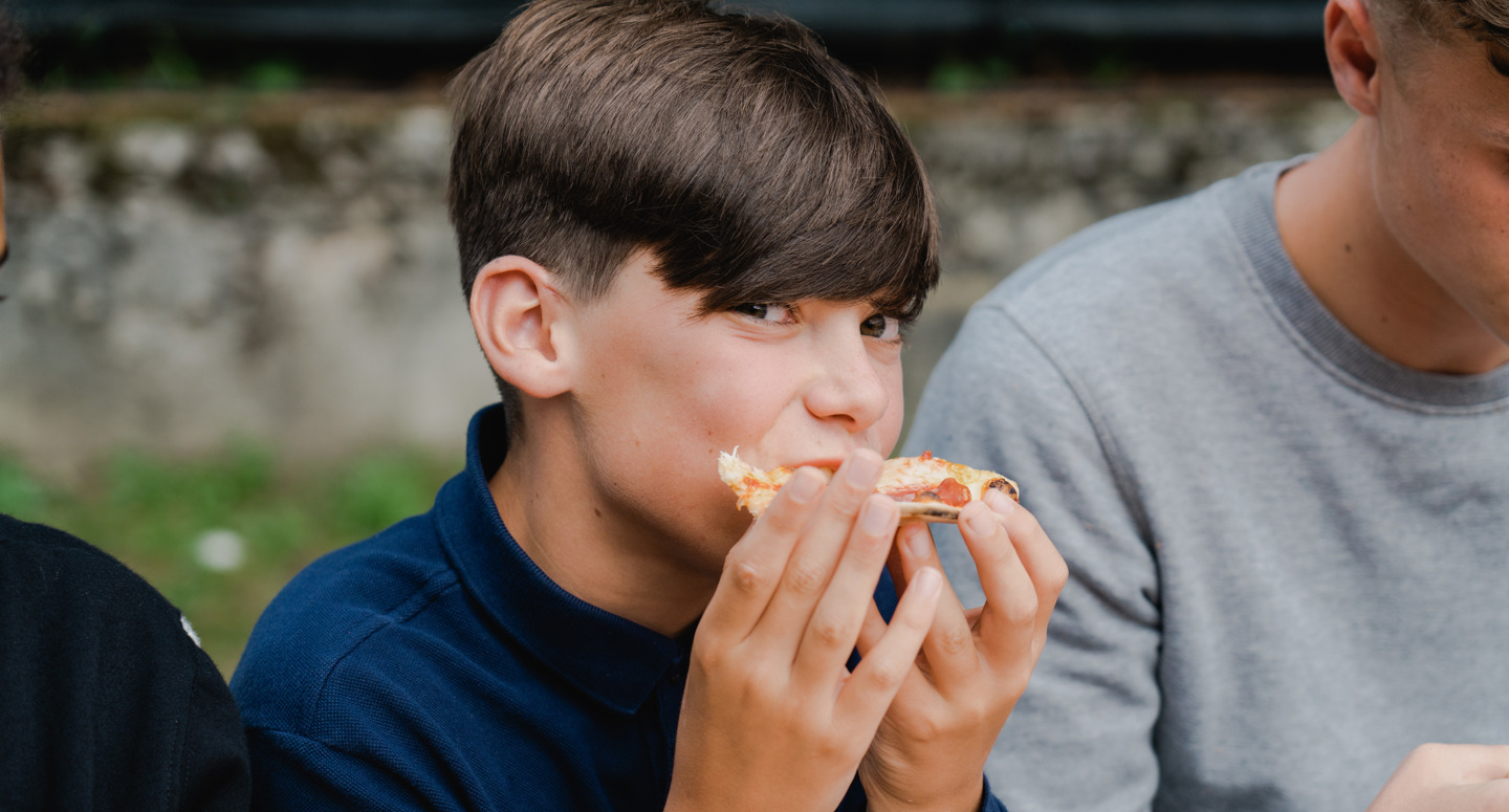 Een jongen smult van zijn pizza 