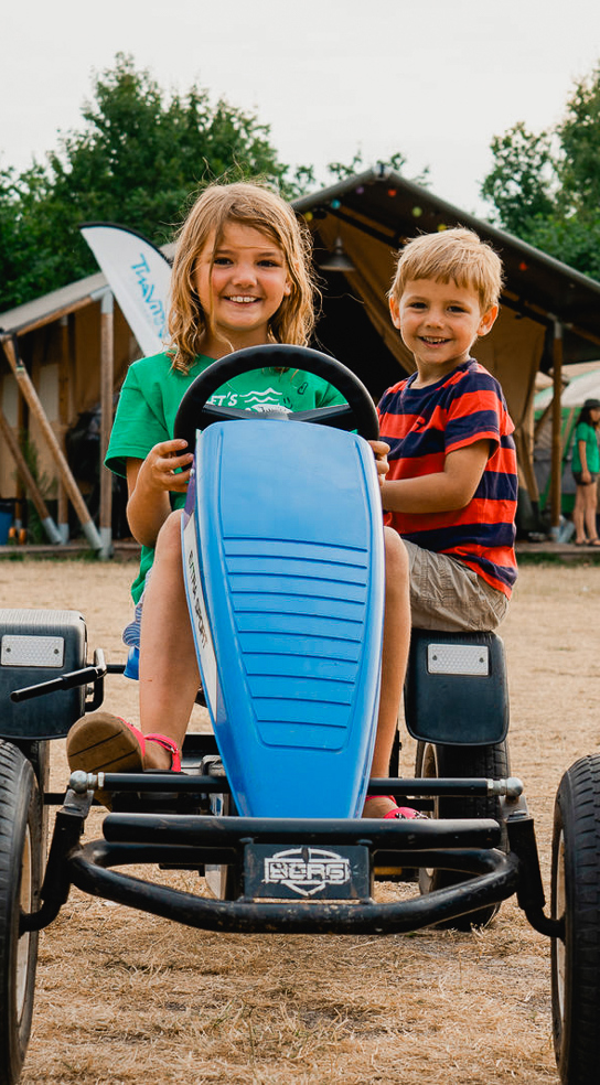 2 kinderen rijden in een skelter op de camping