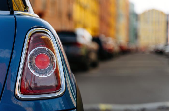 Het rechter achterlicht van een auto die door een stadje rijdt