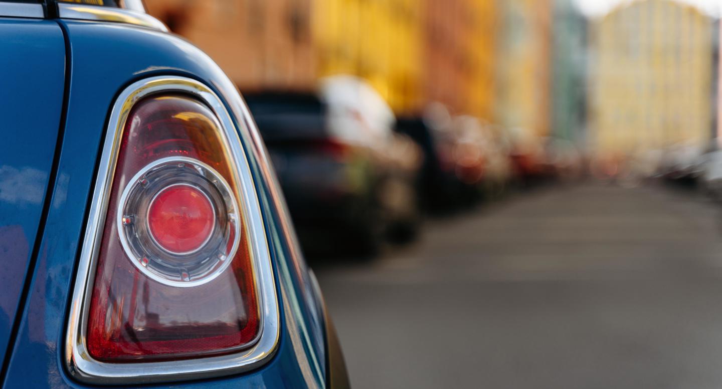 Het rechter achterlicht van een auto die door een stadje rijdt