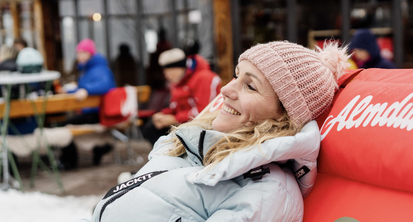 Vrouw geniet op haar ligstoel bij een Oostenrijkse skihut