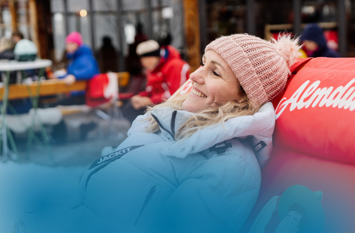 Vrouw geniet op haar ligstoel bij een Oostenrijkse skihut