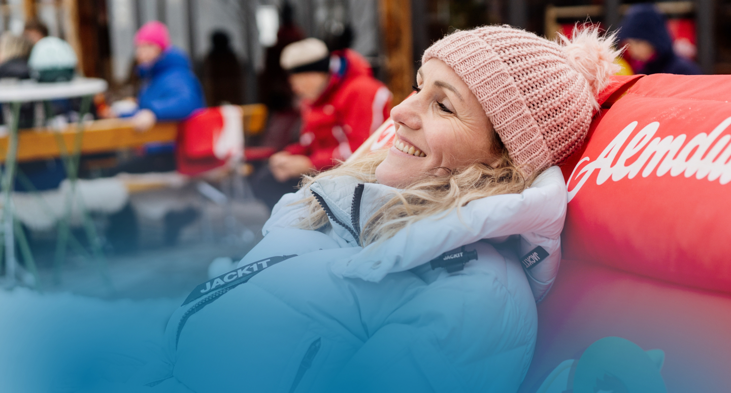 Vrouw geniet op haar ligstoel bij een Oostenrijkse skihut