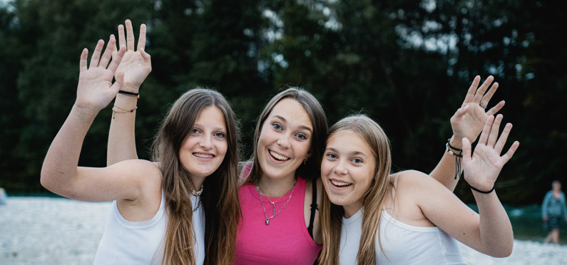 Drie tienermeiden poseren lachend voor een foto