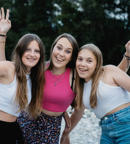 Drie tienermeiden poseren lachend voor een foto