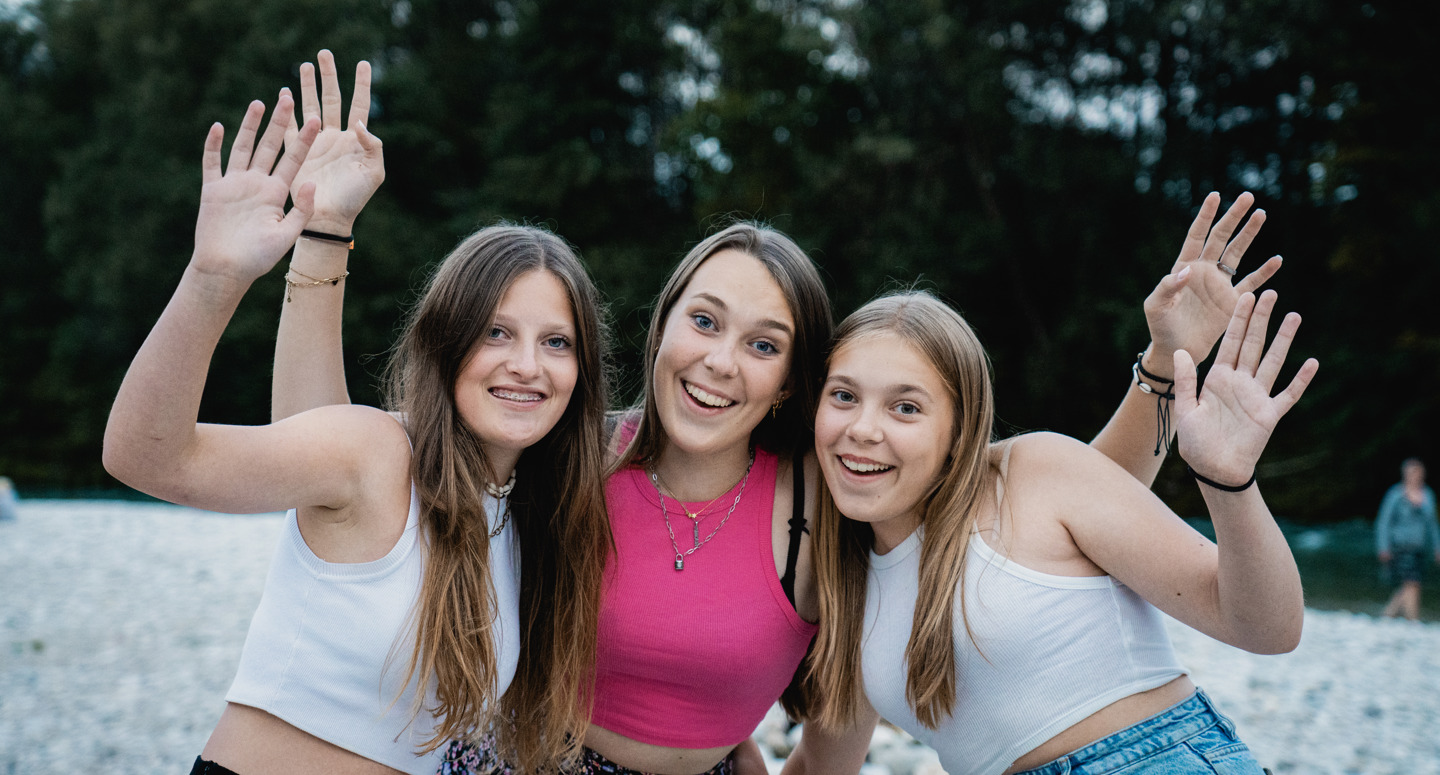 Drie tienermeiden poseren lachend voor een foto
