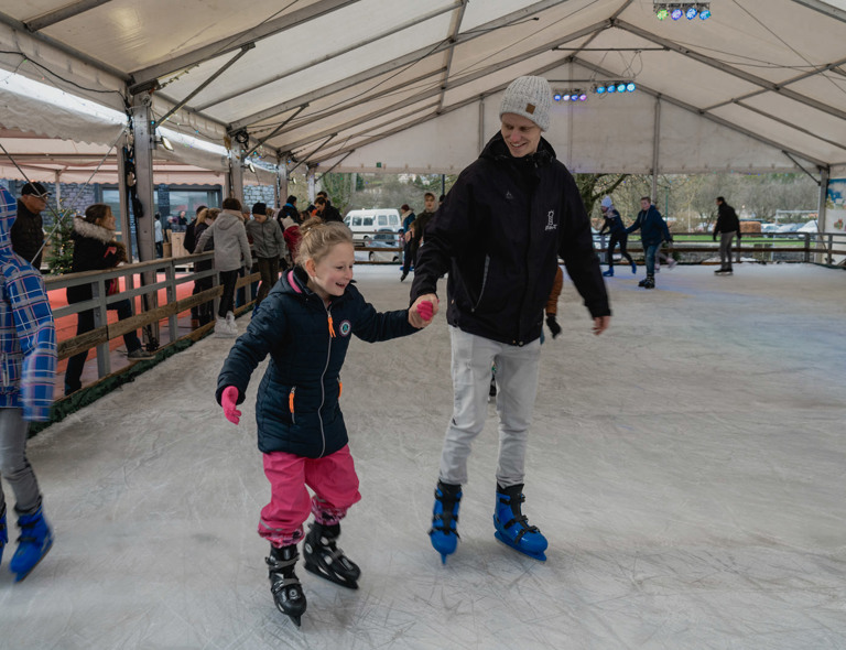 Estivant medewerker schaatst met een kind