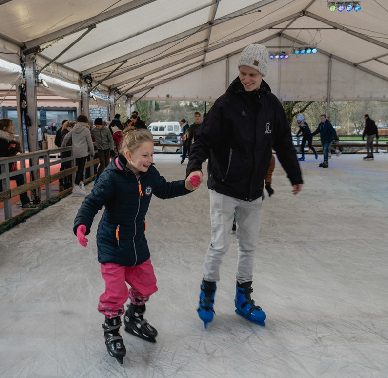 Estivant medewerker schaatst met een kind
