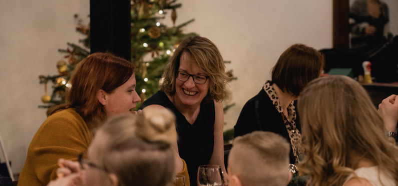 Lachende moeders bij het Estivant kerstdiner